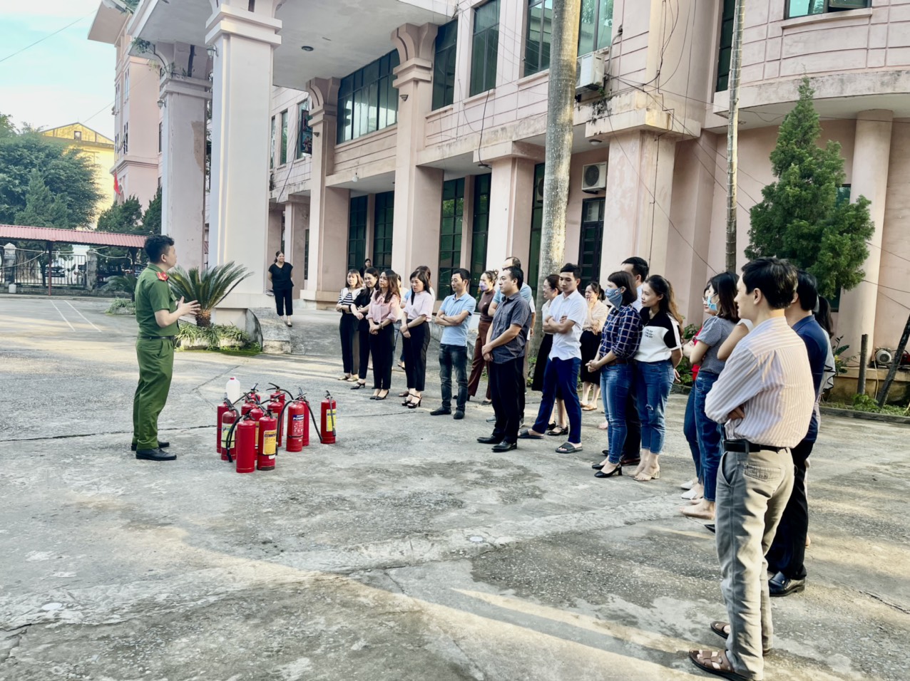 Thượng úy Nguyễn Anh Tuấn đang hướng dẫn cho cán bộ, công chức, viên chức và người lao động về việc sử dụng các thiết bị chữa cháy